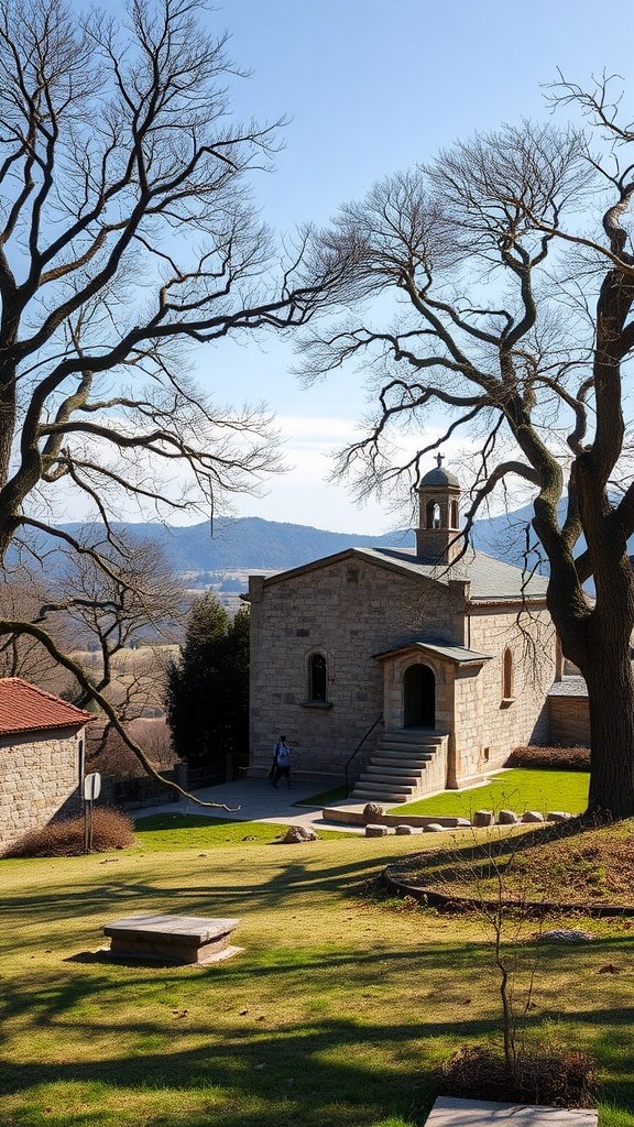 A historical stone monastery set against a clear sky, surrounded by trees and a peaceful landscape.